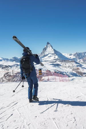 Young skier enjoying Zermatt ski resort. Beautiful sunny day with a skier up in the mountains.の写真素材