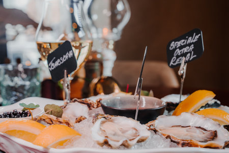 Fresh Oysters close up on a plate, served table with oysters, lemon and ice. Healthy sea food.の写真素材