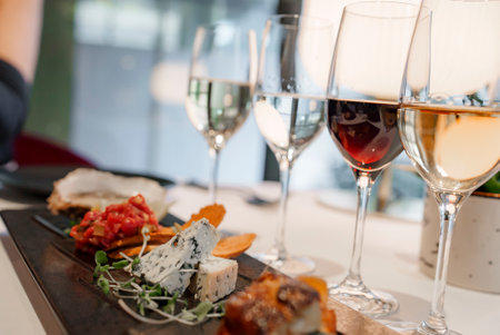 Appetizers with wineglasses on dining table at luxury restaurantの写真素材