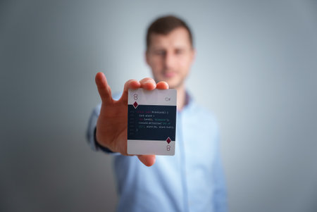 Young man holding a programming cards in his hand.