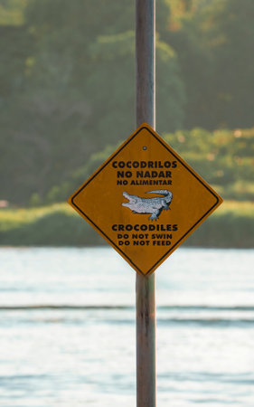 Caution crocodile area do not swim and do not feed message on signboardの写真素材