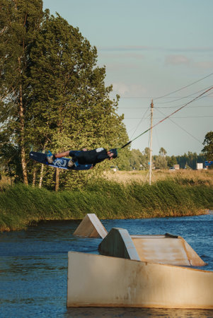 Low angle shot of man wakeboarding on a lake. Man water skiing at sunset.の写真素材
