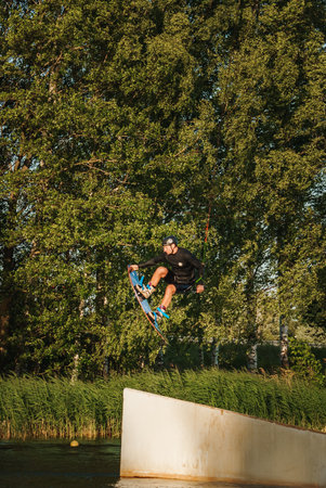 Low angle shot of man wakeboarding on a lake. Man water skiing at sunset.の写真素材
