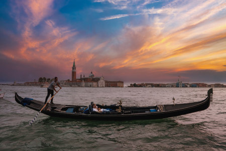 Traditional Venetian gondola ride through picturesque canals with man in traditional attire.の写真素材