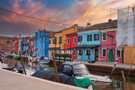 Scenic Venice: Boat Docked in Front of Colorful Building in Charming Italian Cityの写真素材