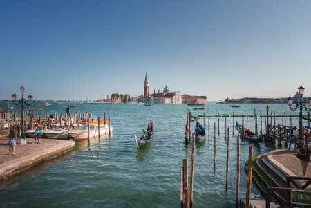 Tranquil Venice: Serene Gondolas Reflecting on Calm Waters in Summerの写真素材