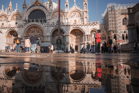Partial Reflection of Ornate San Marco Building in Rippled Puddle, Venice, Italyの写真素材