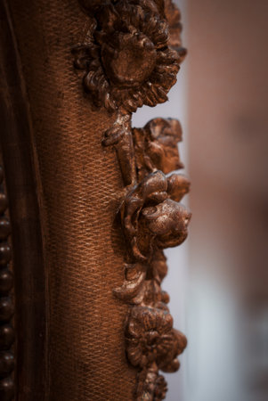 Close-up of Intricately Carved Wooden Frame Hanging on Wall in Brown Colorの写真素材