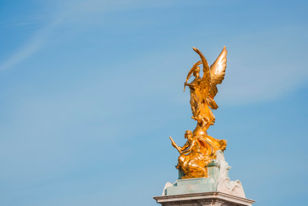 The Angel of Victoria Memorial with blue sky in background. Famous iconic statue of London. Golden sculpture on sunny day.の写真素材