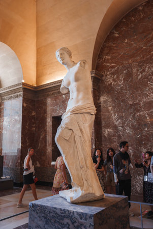 Life-sized white marble statue displayed in a museum setting, showcasing neoclassical artistry and elegant craftsmanship against marble walls.の写真素材