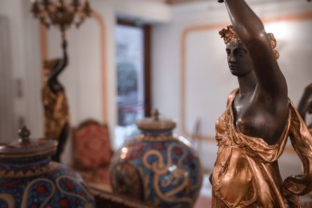 A statue of a woman holding vases in a simple room. The woman stands with vases in both hands. Classic, elegant, and timeless art.の写真素材