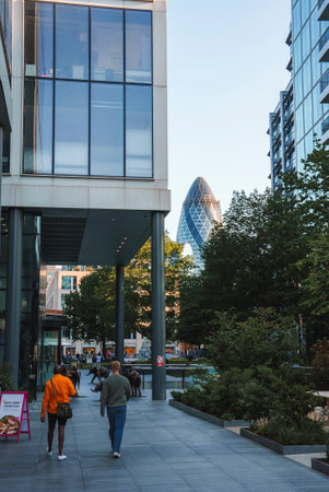 Tourists walking on sidewalk with the Gherkin in backgroundの写真素材