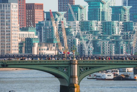 Tourists exploring on Westminster bridge over Thames river in London