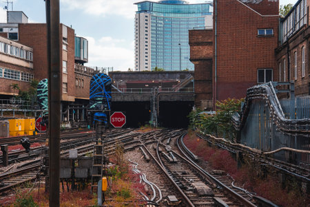 Railroad tracks amidst buildings leading towards tunnel.の写真素材