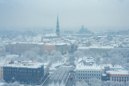 Winters Serenity in Riga A SnowCovered Cityscape with Notable Landmarks.の写真素材