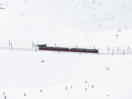 Colorful Train Amid Skiers in Snowy Zermatt, Switzerland Aerial Viewの写真素材