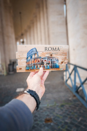 Person holding souvenir of Colosseum with ROMA and COLOSSEO in Rome.