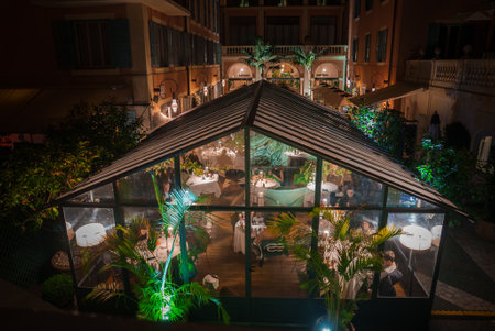 Luxury Restaurant Outdoor Dining with Lush Greenery, Nighttime Ambianceの写真素材
