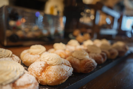 Delicious Cream Filled Pastries Arranged on Dark Tray in Bakery Setting