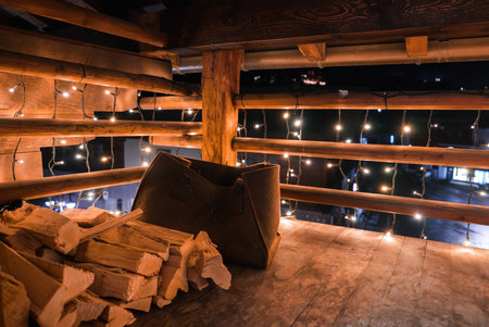 Rustic Wooden Box with Firewood and String Lights in Cozy Indoor Cabin.