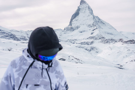 Winter sports enthusiast admires Matterhorn mountain in Zermatt, Switzerlandの写真素材