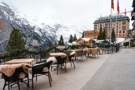Alpine Terrace Dining with Modern Wicker Chairs and Snowy Mountain View