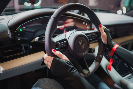 Luxury Car Steering Wheel with Drivers Hands, Red Nail Polish, and Digital Display Interior Designの写真素材