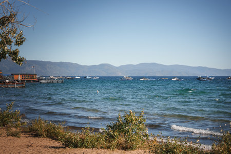Tranquil Lakeside Scene with Moored Boats and Mountains, USAの写真素材
