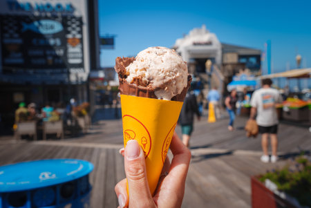 Person holds chocolate chip ice cream cone at Pier 39, San Franciscoの写真素材