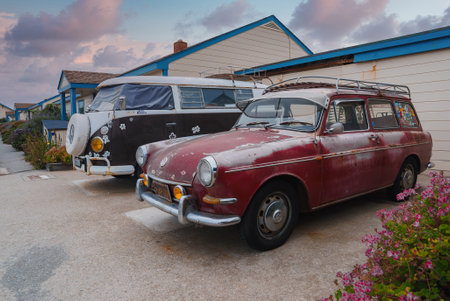 Vintage Volkswagen Bus and Red Station Wagon Parked Near Blue Building on California Coastの写真素材