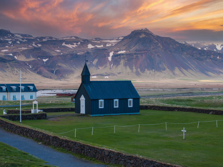 Budir Black Church with Mountain Range and Pink Orange Sky in Icelandの写真素材