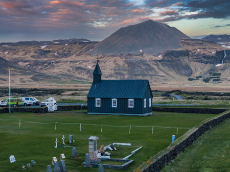 Aerial View of Black Church with Mountain and Pink Sky in Icelandの写真素材