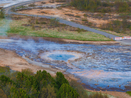 Aerial View of Erupting Geyser with Vibrant Blue Pool in Icelandの写真素材
