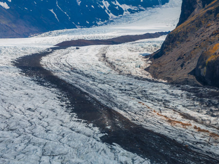 Aerial View of Snow-Covered Glacier with Rocky Ridge in Icelandの写真素材
