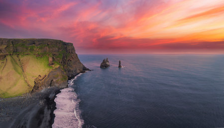 Aerial View of Icelandic Cliff and Black Sand Beach at Sunset with Sea Stacksの写真素材