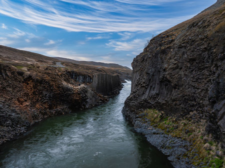 Aerial View of Turbulent River Flowing Through Steep Canyon in Icelandの写真素材