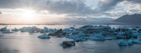 Beautiful sunset with melting icebergs of emerald turquoise blue in Jokulsarlon