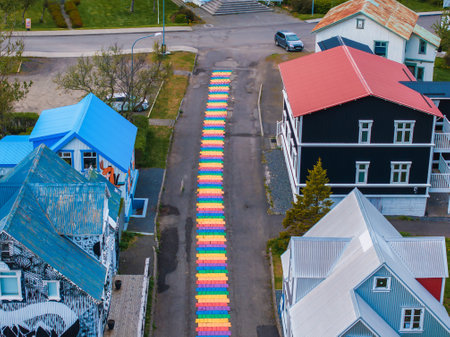 The famous rainbow road in Seydisfjordur with icelandic buildings around show artwork painted walls.の写真素材