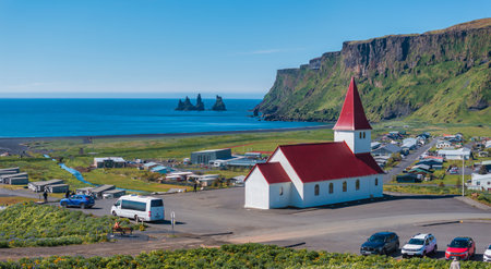 White Church with Red Roof Overlooking Black Sand Beach in Vik i Myrdal, Icelandの写真素材
