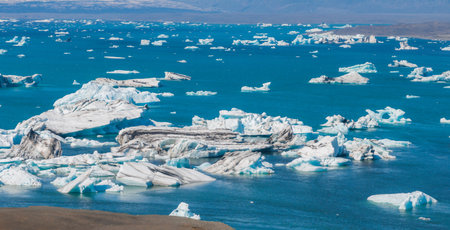 Aerial view of the big pieces of ice from glacier, ice islands, glacier and mountains, Jokulsarlon