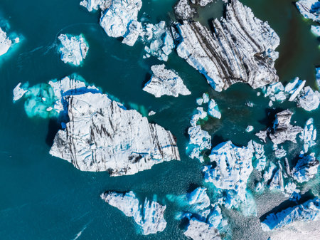 Aerial view of the big pieces of ice from glacier, ice islands, glacier and mountains, Jokulsarlon