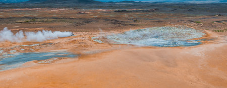 Aerial View of Geothermal Crater with Blue Water and Orange Mud in Iceland