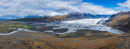 Aerial View of Glacial Valley with Lake and Snow-Capped Mountains in Icelandの写真素材