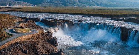 Aerial View of Majestic Waterfall Cascading Over Rocky Cliff in Icelandの写真素材