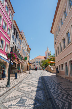 Charming Street with Colorful Buildings and White Church in Aveiro, Portugalの写真素材