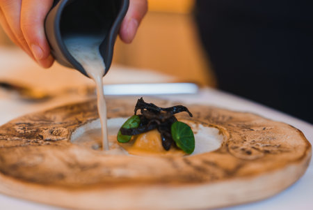 Luxurious Dining Experience with Gourmet Dish and Creamy Sauce Pouringの写真素材