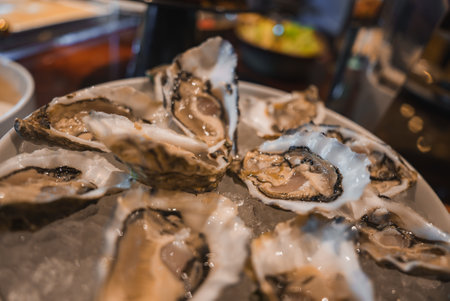 Luxurious Plate of Fresh Oysters on Ice in Elegant Dining Settingの写真素材