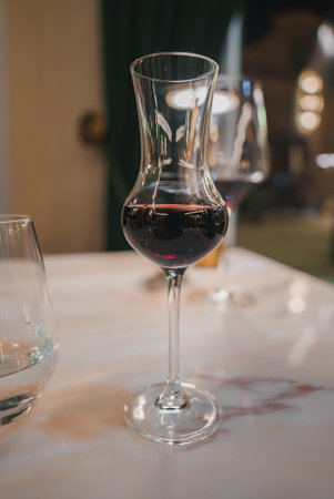 Elegant Glass of Red Wine on Marble Table in Luxurious Hotel Settingの写真素材