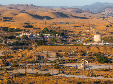 Desert Landscape with Oil Rigs and Rolling Hills in Californiaの写真素材