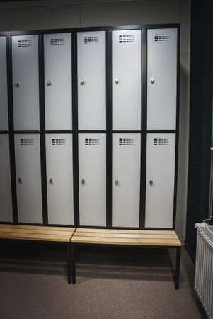 Modern Locker Room with Black Framed White Lockers and Wooden Benchの写真素材
